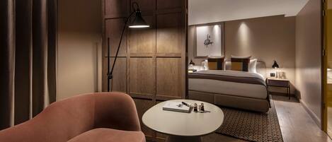 Une chambre d’hôtel moderne avec un grand lit, une petite table ronde, un canapé et une lampe de bureau.