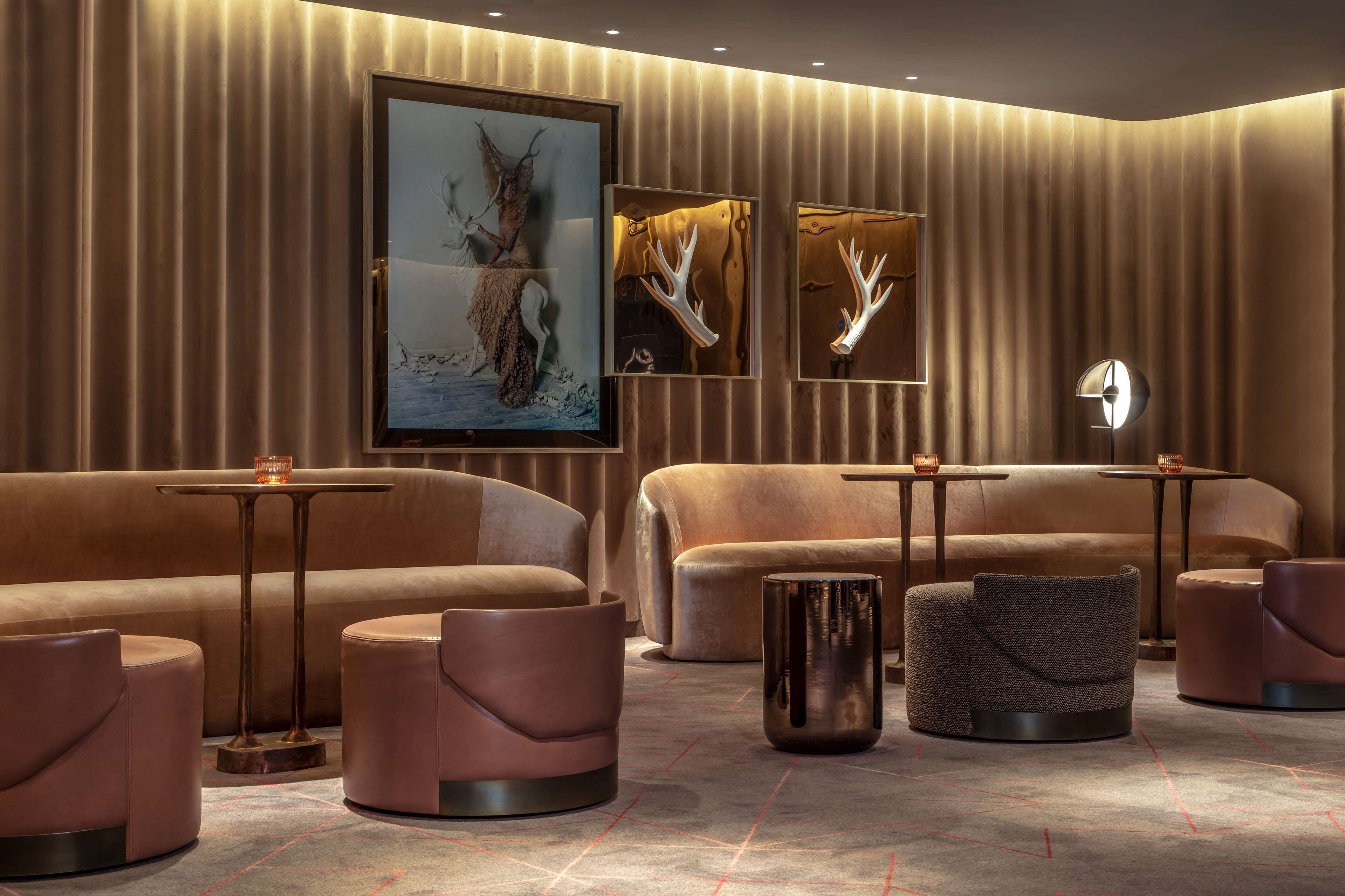 A modern lounge area with plush seating, framed artwork, and ambient lighting.