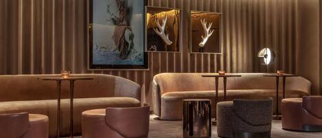 A modern lounge area with plush seating, framed artwork, and ambient lighting.