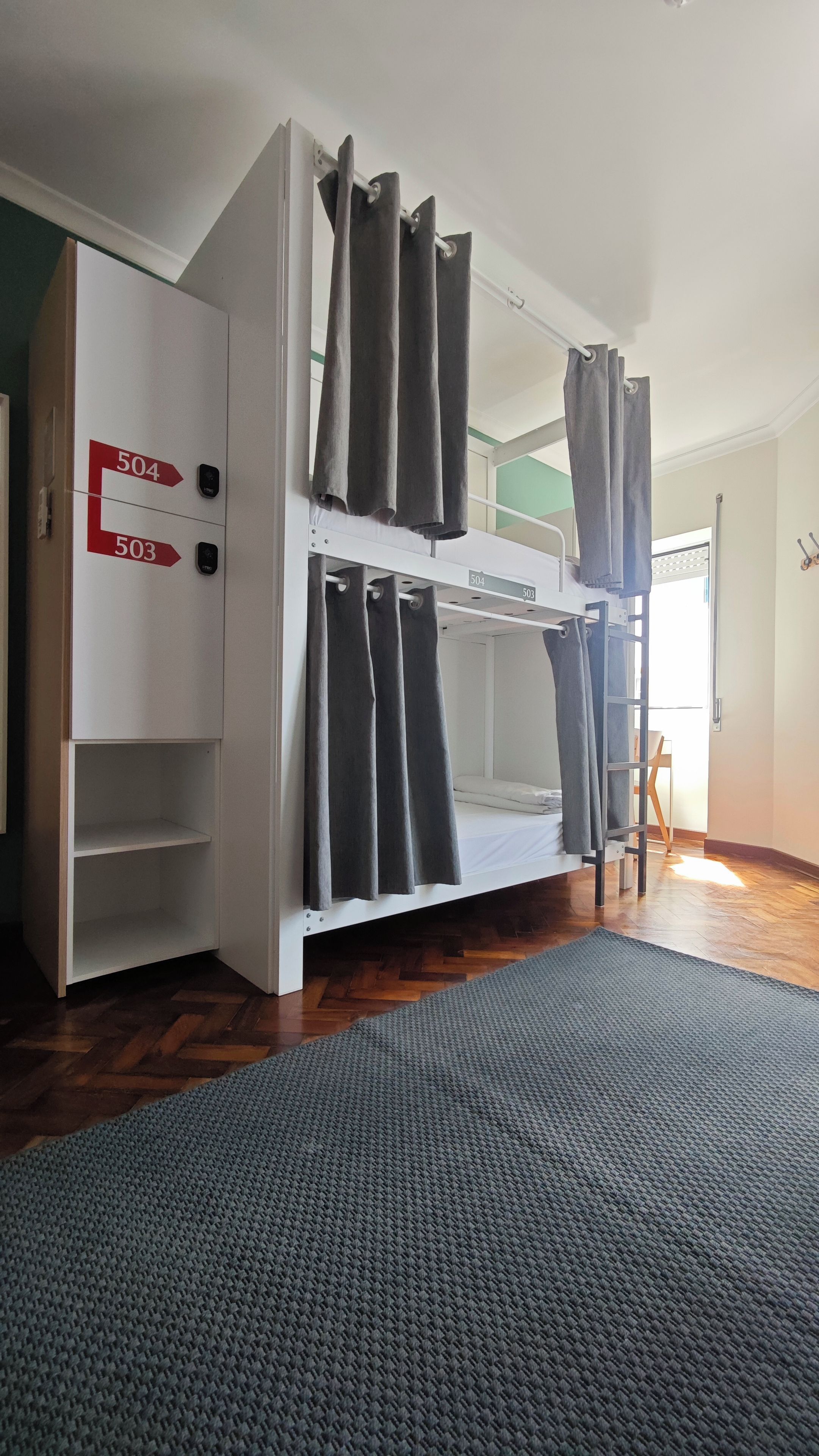 A bunk bed room with a wardrobe and a door with directional arrows.