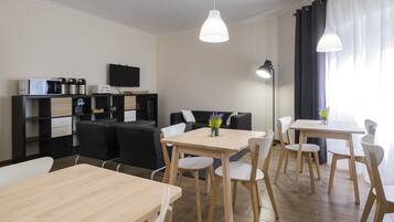 Una sala de estar moderna con un sofá, una mesa de centro y un comedor con sillas y una mesa.