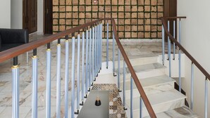 A staircase with a modern design, featuring a wooden handrail and metal balusters. - Passal Hostel (Ponta Delgada)