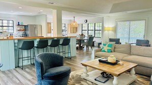 A spacious living area with a kitchen, bar, and seating.