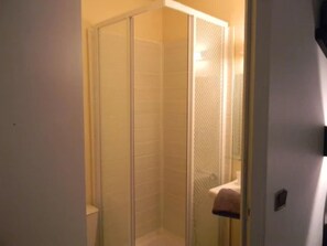 A small, enclosed shower area with a glass door and a towel hanging on the wall. - Class Hôtel Poitiers (Poitiers)