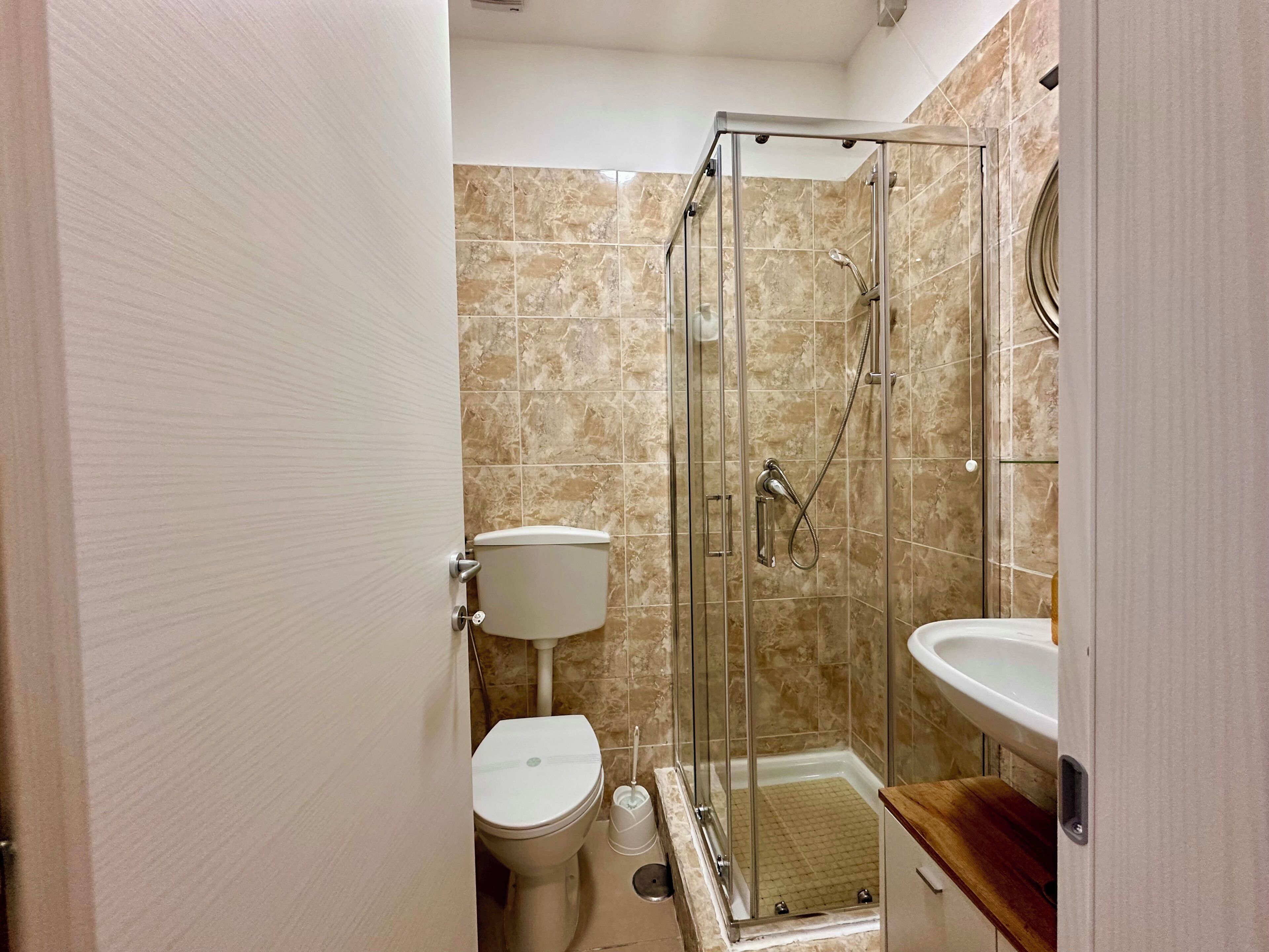 Ein Badezimmer mit Duschkabine, Toilette und Waschbecken.