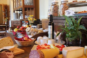 A buffet with various cheeses, fruits, and bread. - Agriturismo Fattoria Del Colle (Trequanda)