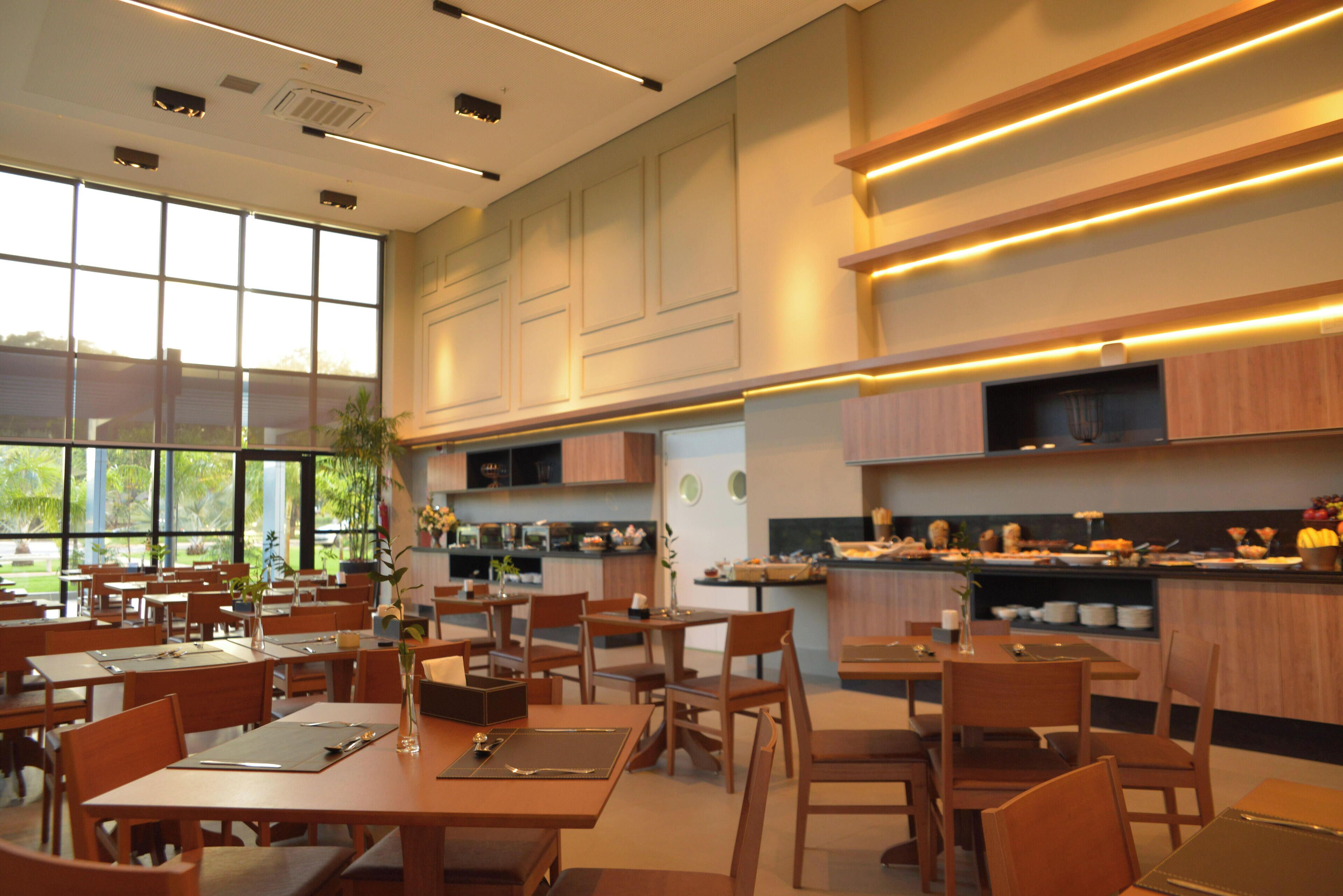 Un restaurant moderne avec des meubles en bois, de grandes fenêtres et un espace buffet.