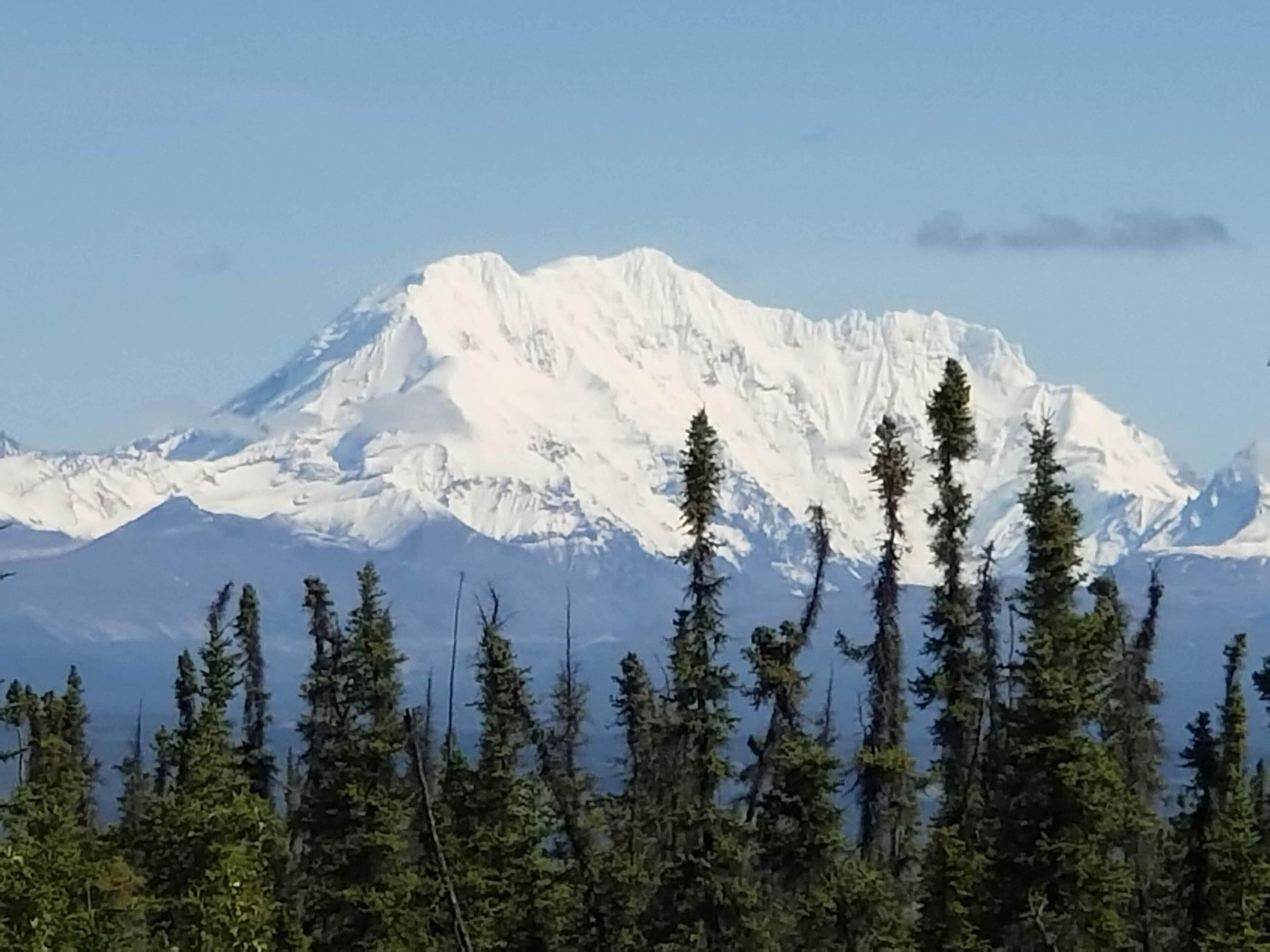 A snow-covered mountain with a clear sky.