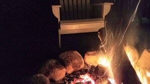 A wooden chair near a campfire with rocks. - #4 Adirondack FamilyFriendly Waterfront on LoonLake. Boating,fishing,swimming!  (Chestertown)