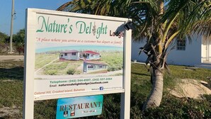 A sign for Nature's Delight Lodge with contact information and a photo of the property. - Nature's Delight Lodge (Colonel Hill)