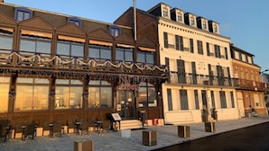 Un bâtiment doté d’un espace extérieur abrité avec des sièges et d’une grande façade vitrée.