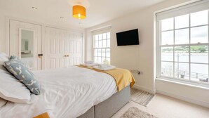 A bedroom with a bed, a television, a window with a view, and a door. - 2 Bed in Appledore (oc-loblof) (Appledore)