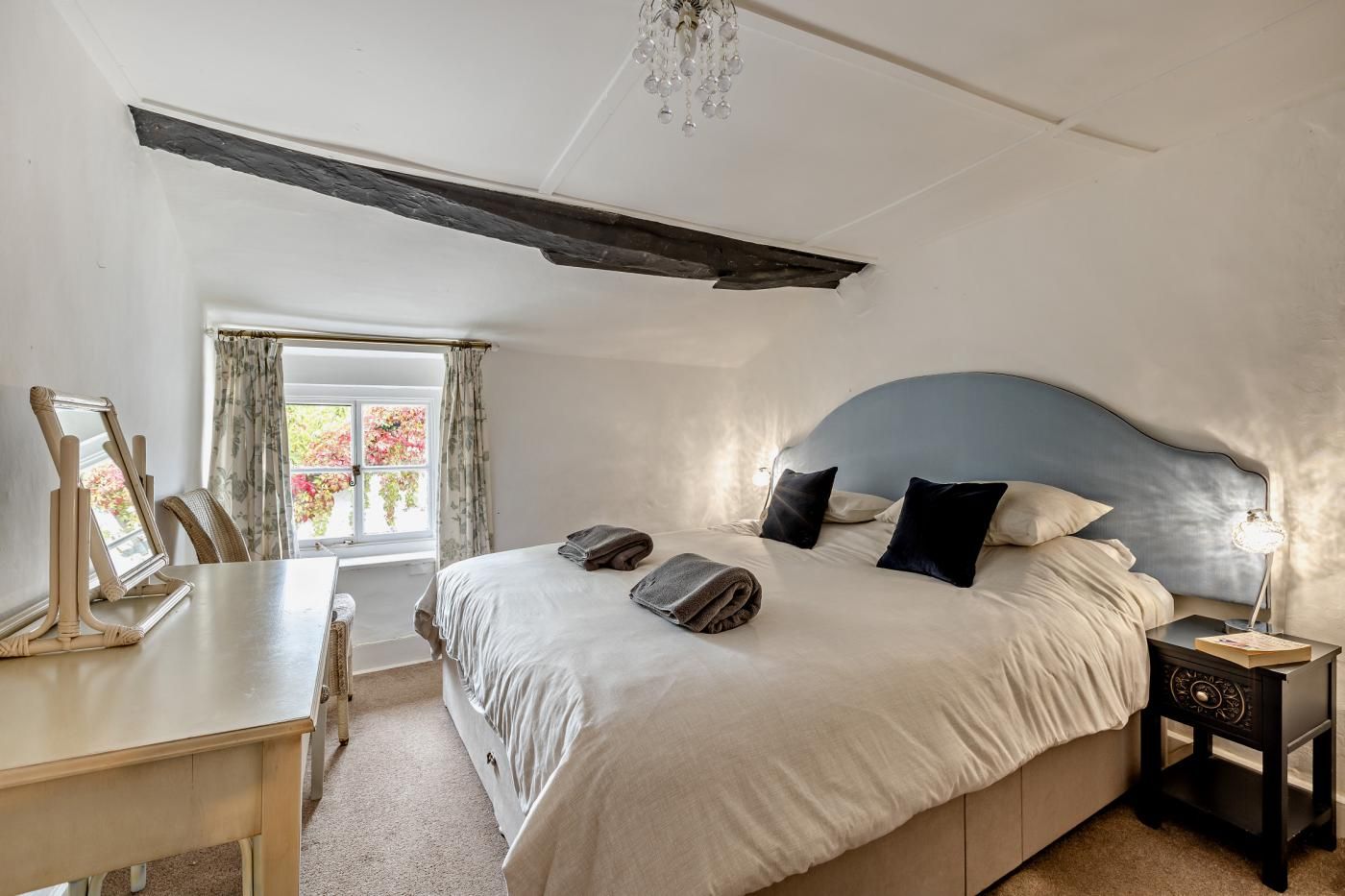Une chambre à coucher avec un lit, une table de chevet et un bureau avec une chaise.