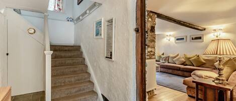 A staircase leading to a living area with a sofa and lamp.