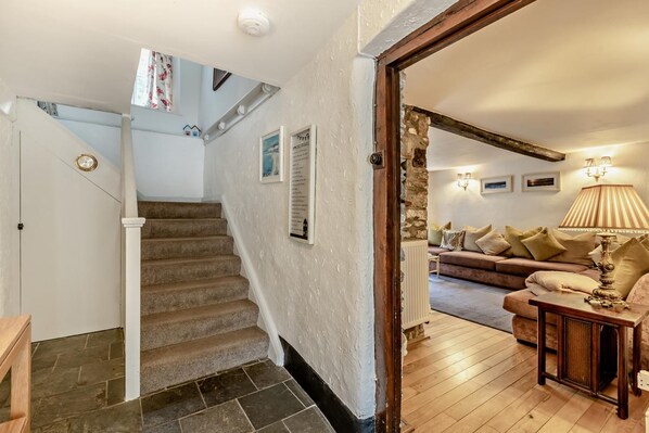 A staircase leading to a living area with a sofa and lamp.