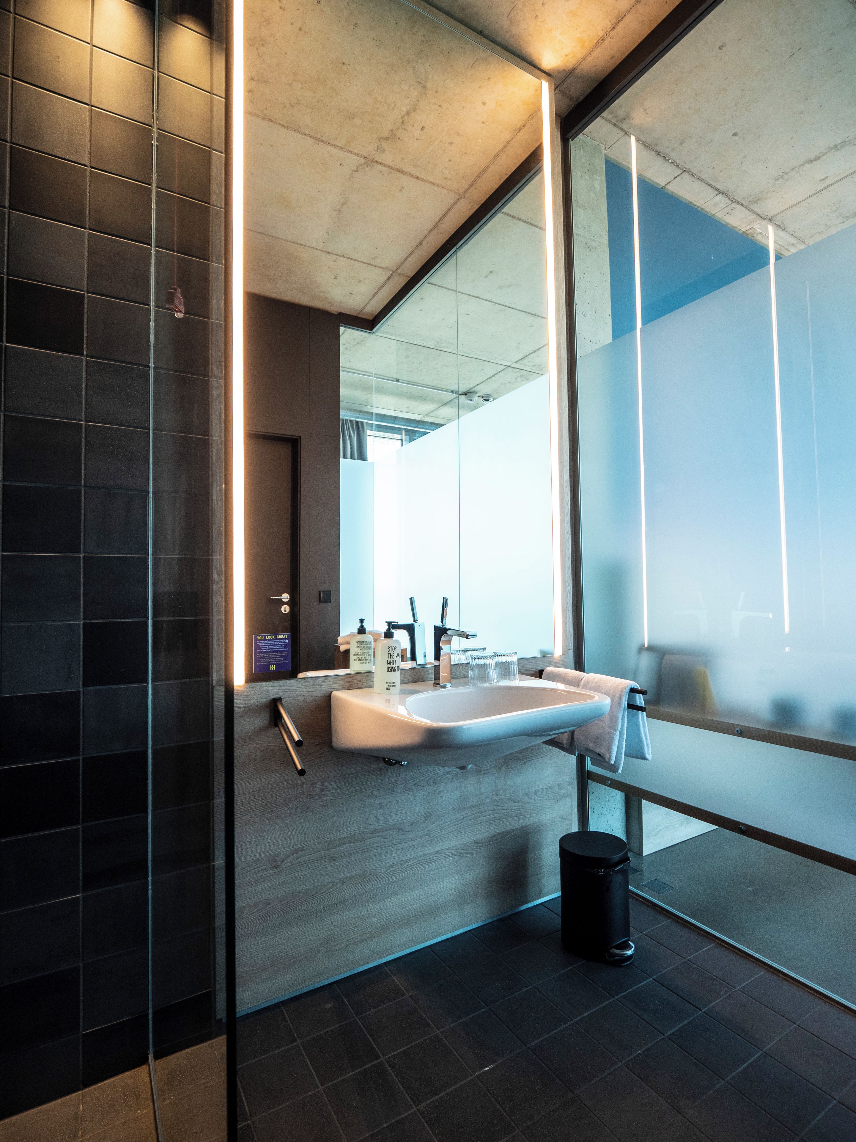 Un bany modern amb un gran mirall, un lavabo i un gresol.