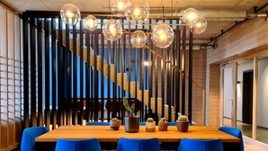 A modern conference room with a wooden table, blue chairs, and a decorative cactus arrangement. - THE CLOUTH (Cologne)