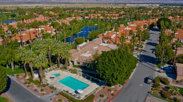Vista aérea de una zona residencial con casas, piscina y campo de golf.