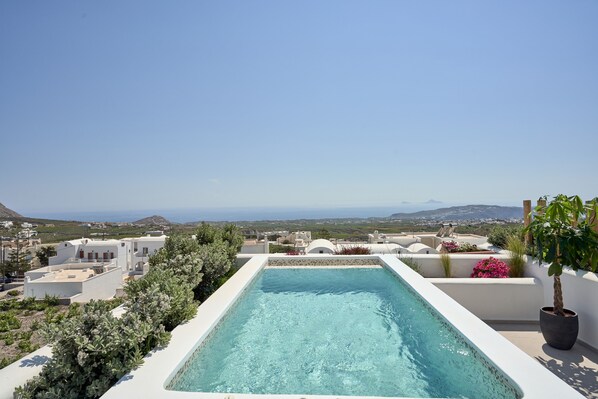A rooftop infinity pool with a clear view of the coastline and surrounding buildings.