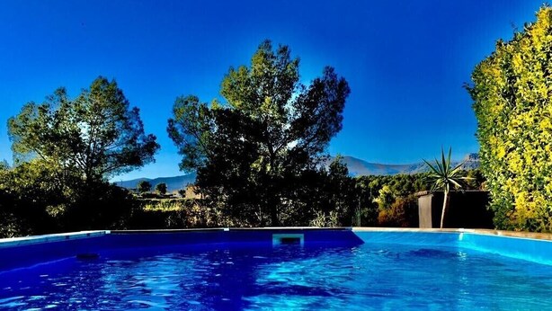 A swimming pool with clear blue water, surrounded by trees and a mountain in the background. - La Gaude, villa 6 people-garden-pool-open view in a quiet (La Gaude)