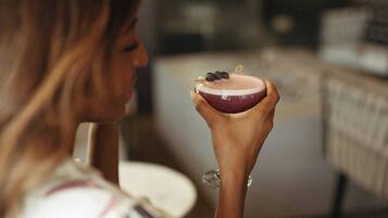 Una persona sostiene un objeto pequeño y redondo, con un centro oscuro y un anillo exterior más claro, posiblemente un postre o un aperitivo.