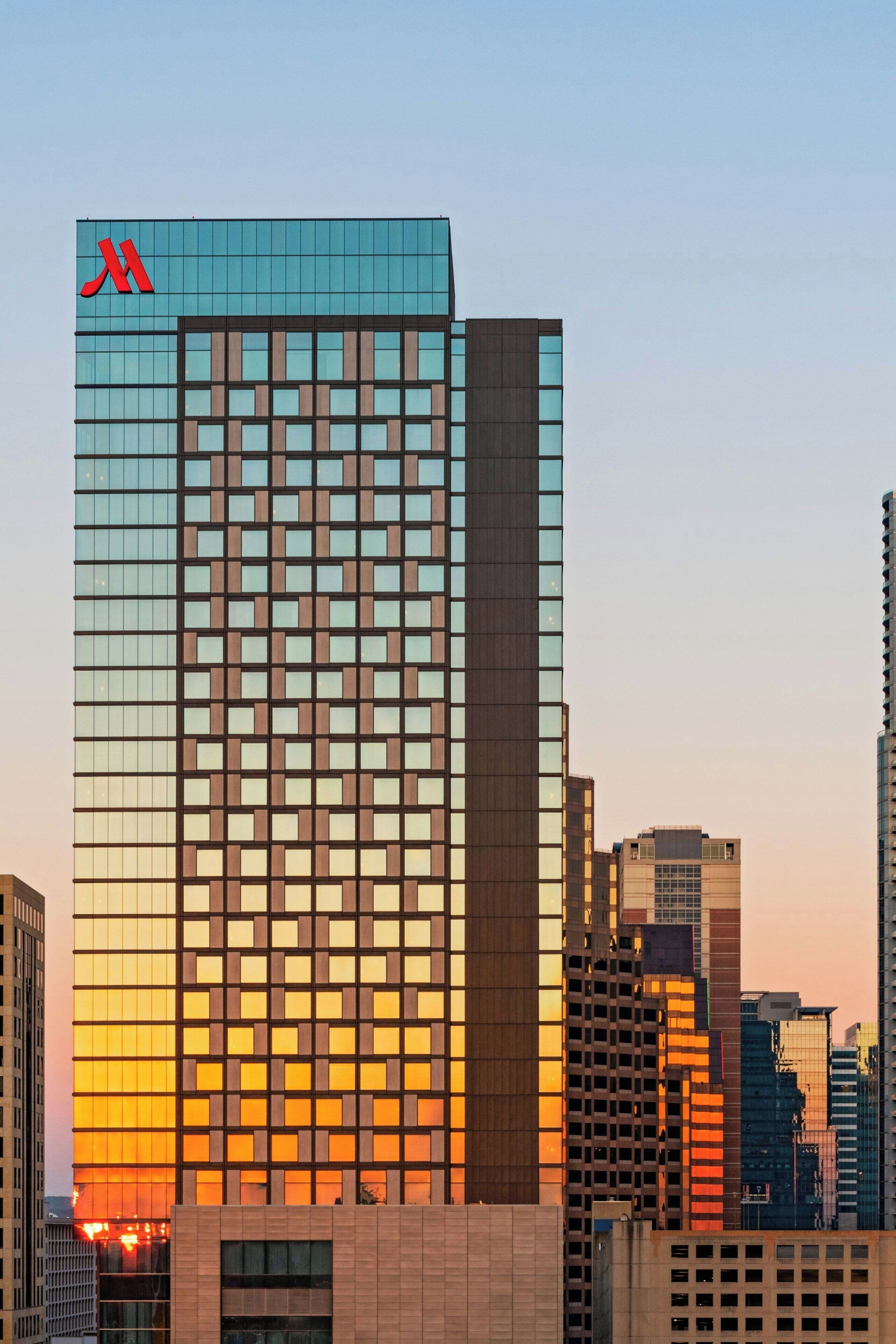 A high-rise building with a distinctive facade featuring a grid of windows and a prominent red logo at the top.