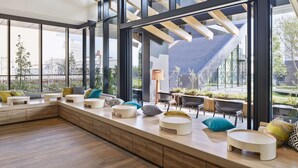 Un intérieur moderne avec un long banc servant de coin salon, de grandes fenêtres et une vue sur l’extérieur.