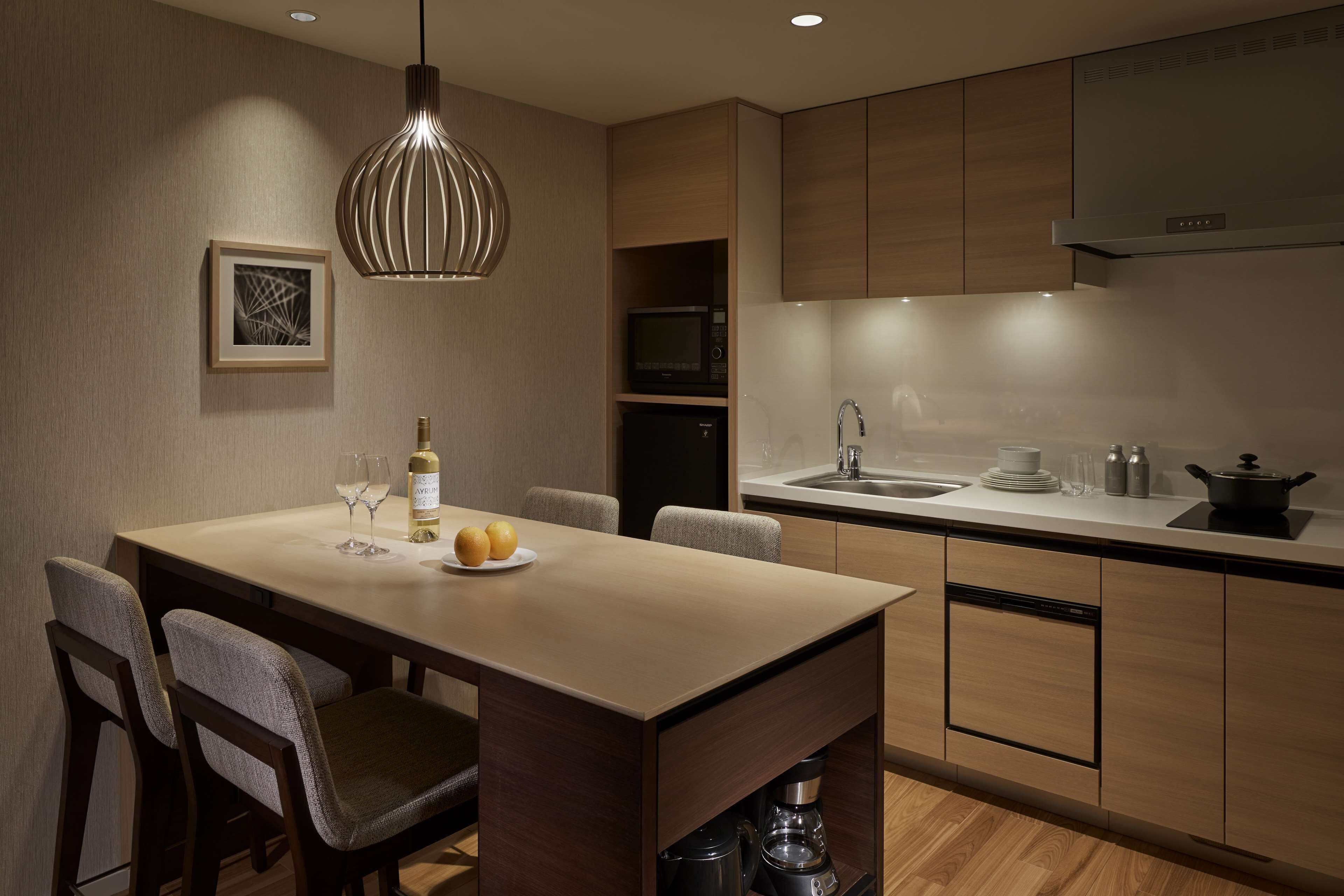 A modern kitchen with a central island, a microwave, a sink, and a built-in oven.
