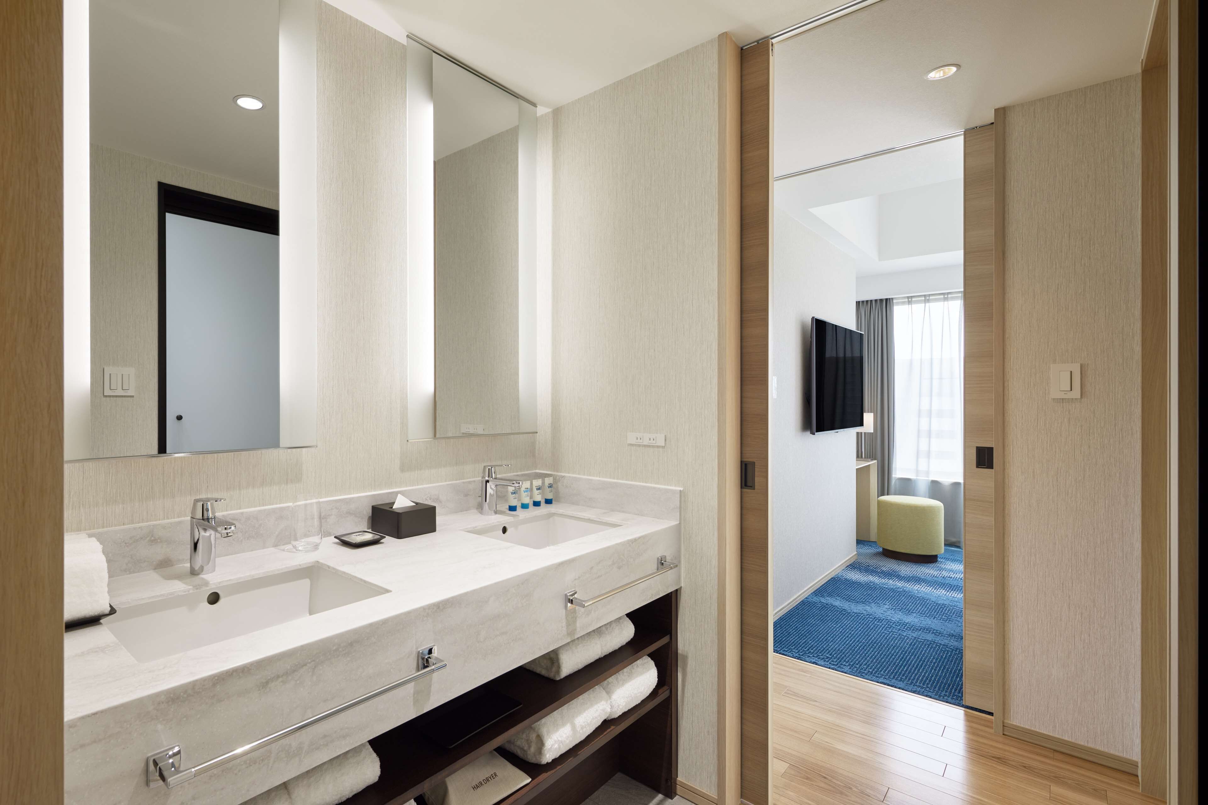 A modern bathroom with a large sink, mirror, and built-in towel rack.