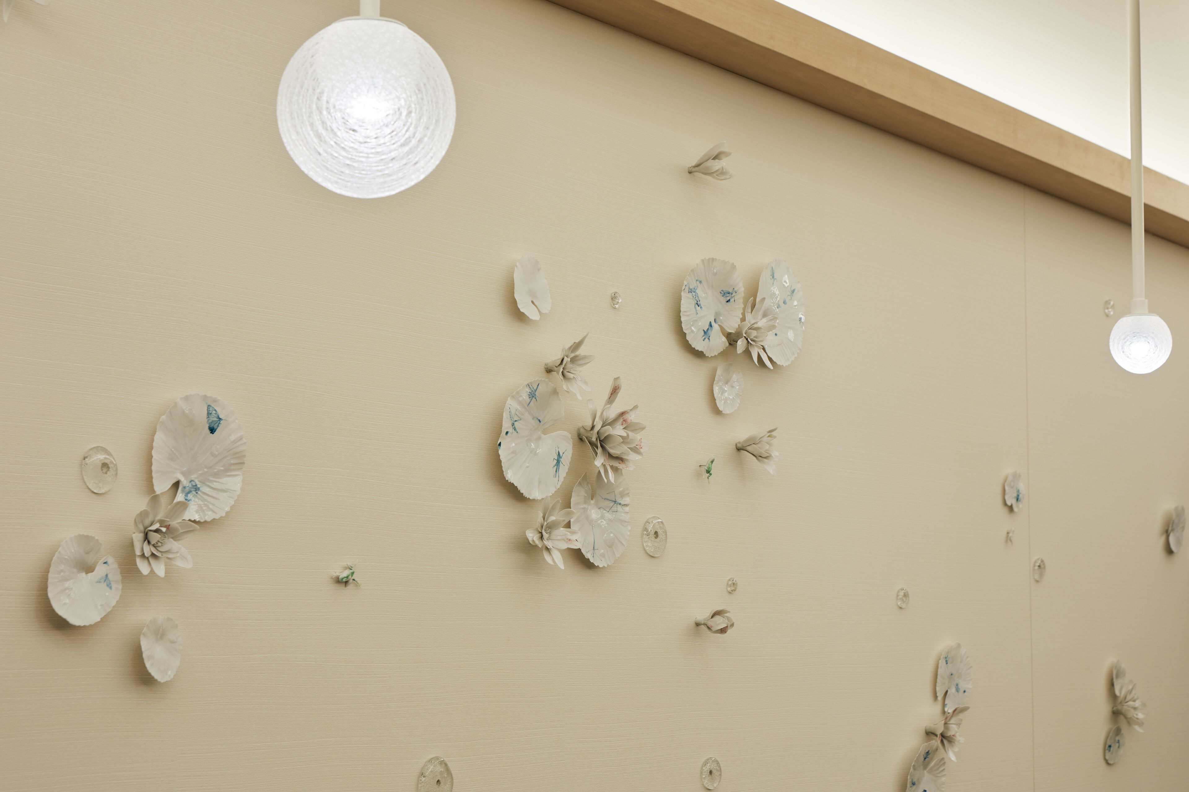 A wall with decorative paper flowers and a hanging light fixture.