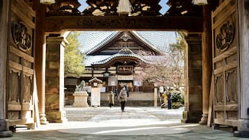 A traditional Japanese gate with intricate woodwork and a sign above it.