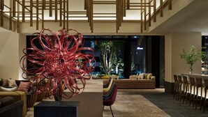Un hall d’entrée spacieux, agrémenté d’un lustre moderne, d’un coin salon et offrant une vue sur l’extérieur.