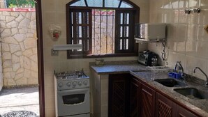 A compact kitchen with a gas stove, a microwave, and a sink.