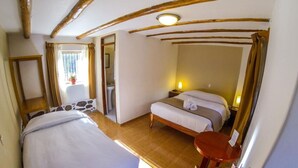 A room with a bed, a small table, and a mirror.