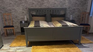 Une chambre à coucher avec un lit, deux tables de chevet, une lampe et une chaise.