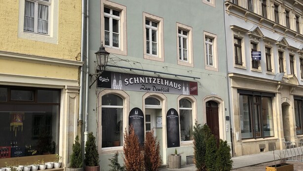 Un bâtiment sur lequel on peut lire l’inscription « Schnitzelhaus Zum Domblick », ce qui indique qu’il s’agit d’un restaurant.