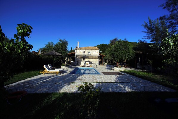 A house with a swimming pool, lounge chairs, and a garden. - Villa 3 Bedroom, Alegria Villas (Zakynthos)