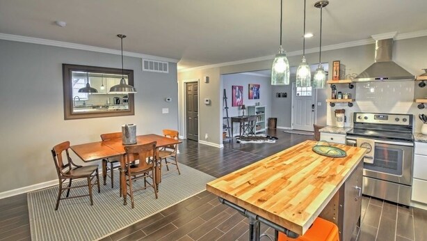 A modern kitchen with a central island, stainless steel appliances, and pendant lighting.