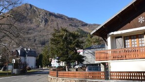 Eine Bergstadt mit einem Holzhaus, das einen Balkon und einen Blick auf die Berge bietet.