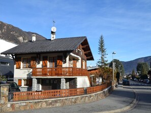 Situated on a mountain street, this chalet-style building features a balcony and steeply pitched roof.