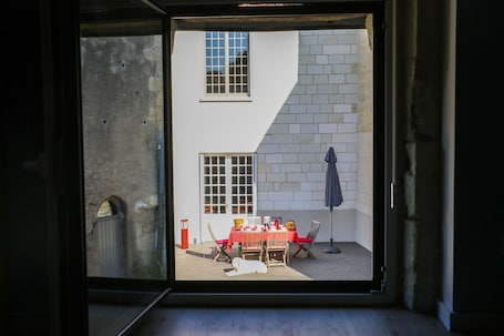 A room with a sliding glass door leading to an outdoor patio area with a table and chairs.