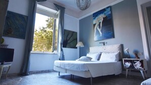 Ein Schlafzimmer mit Bett, Fernseher und Bildern an den Wänden.
