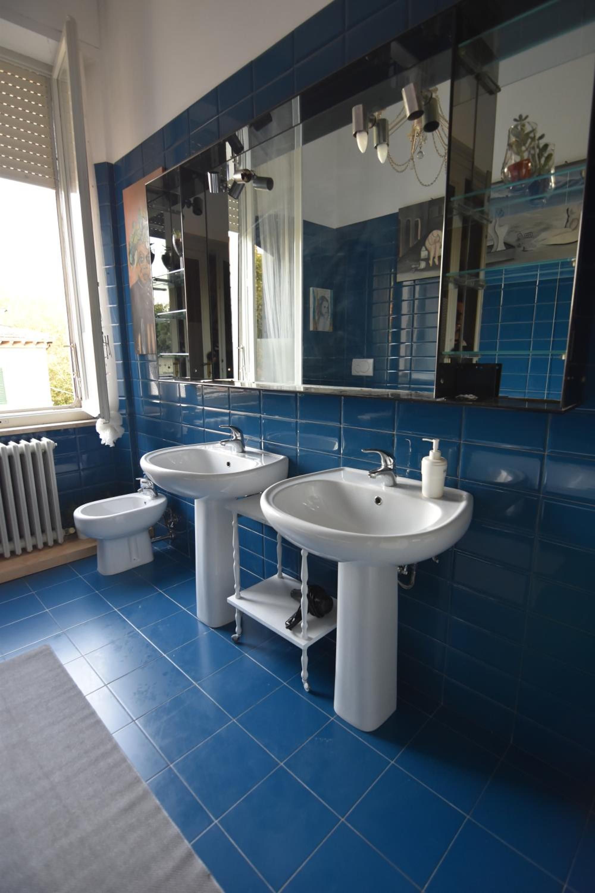 Un bagno con due lavandini, un bidet e un grande specchio.