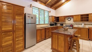 Eine Küche mit Holzschränken, einem Kühlschrank, einem Herd und einem Spülbecken.