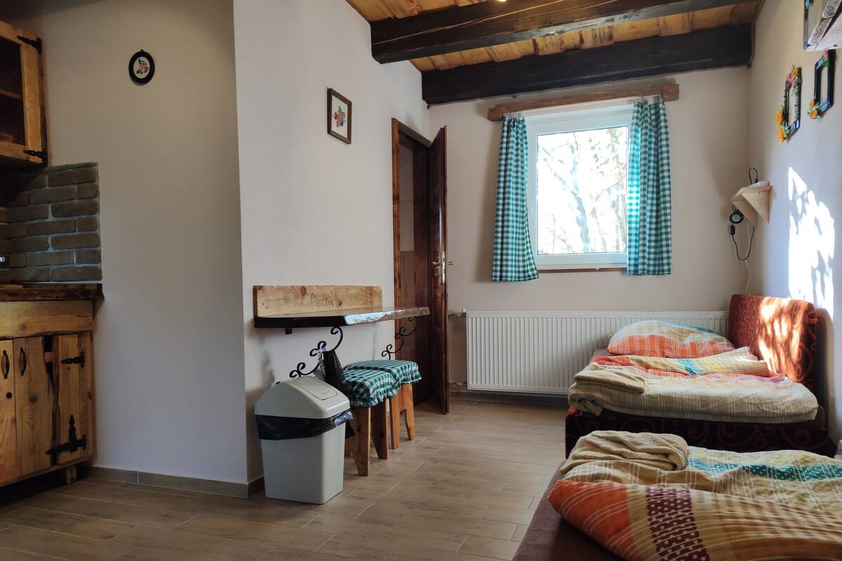 Een gezellige kamer met een bed, een houten kast, een radiator en een raam met gordijnen.