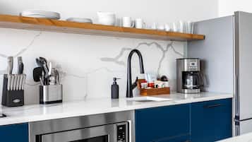 A modern kitchen with a built-in oven, a coffee maker, and a knife block.