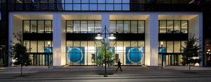 A modern building with large glass windows and a central entrance with a circular design. - Mint House Dallas Downtown by Kasa (Dallas)