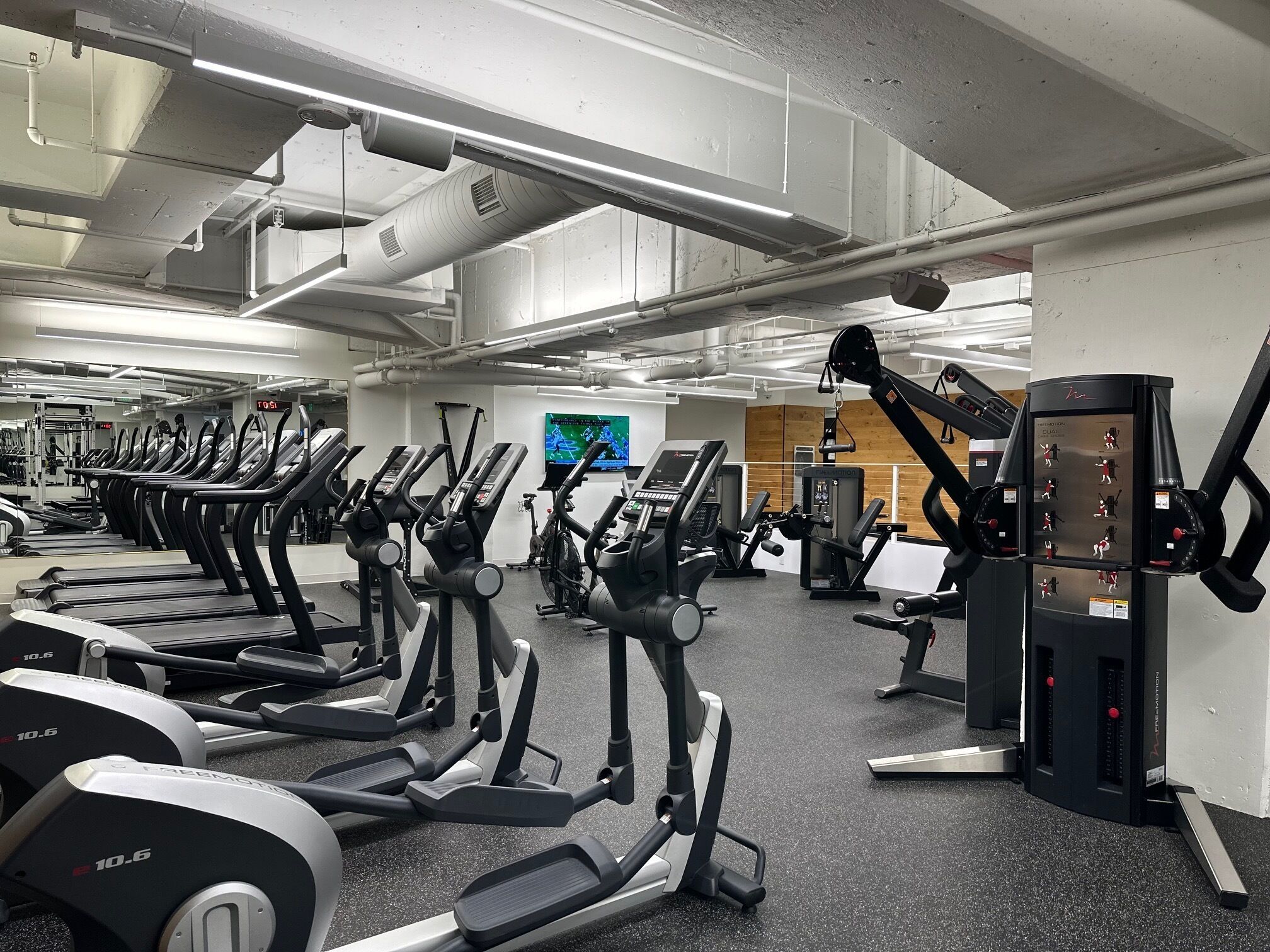 Une salle de sport équipée de plusieurs tapis de course, de vélos d’exercice et d’appareils de musculation.