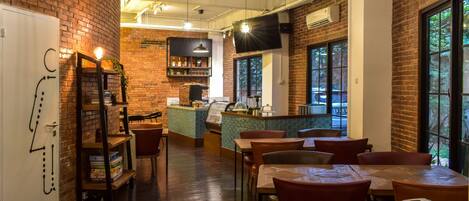 A restaurant with brick walls, wooden tables, and a bar area.