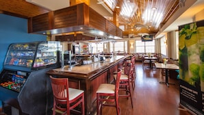 A restaurant with a bar area, wooden ceiling, and a menu board. - Oceanfront Views at Ocean Pointe + Pool + Beach & Marina Access, Updated 2BR (Tavernier)
